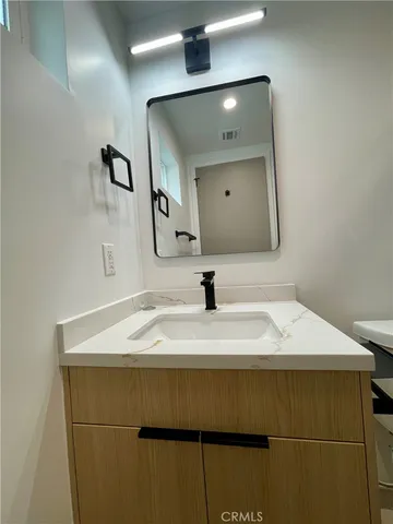 a bathroom with a sink vanity and a mirror