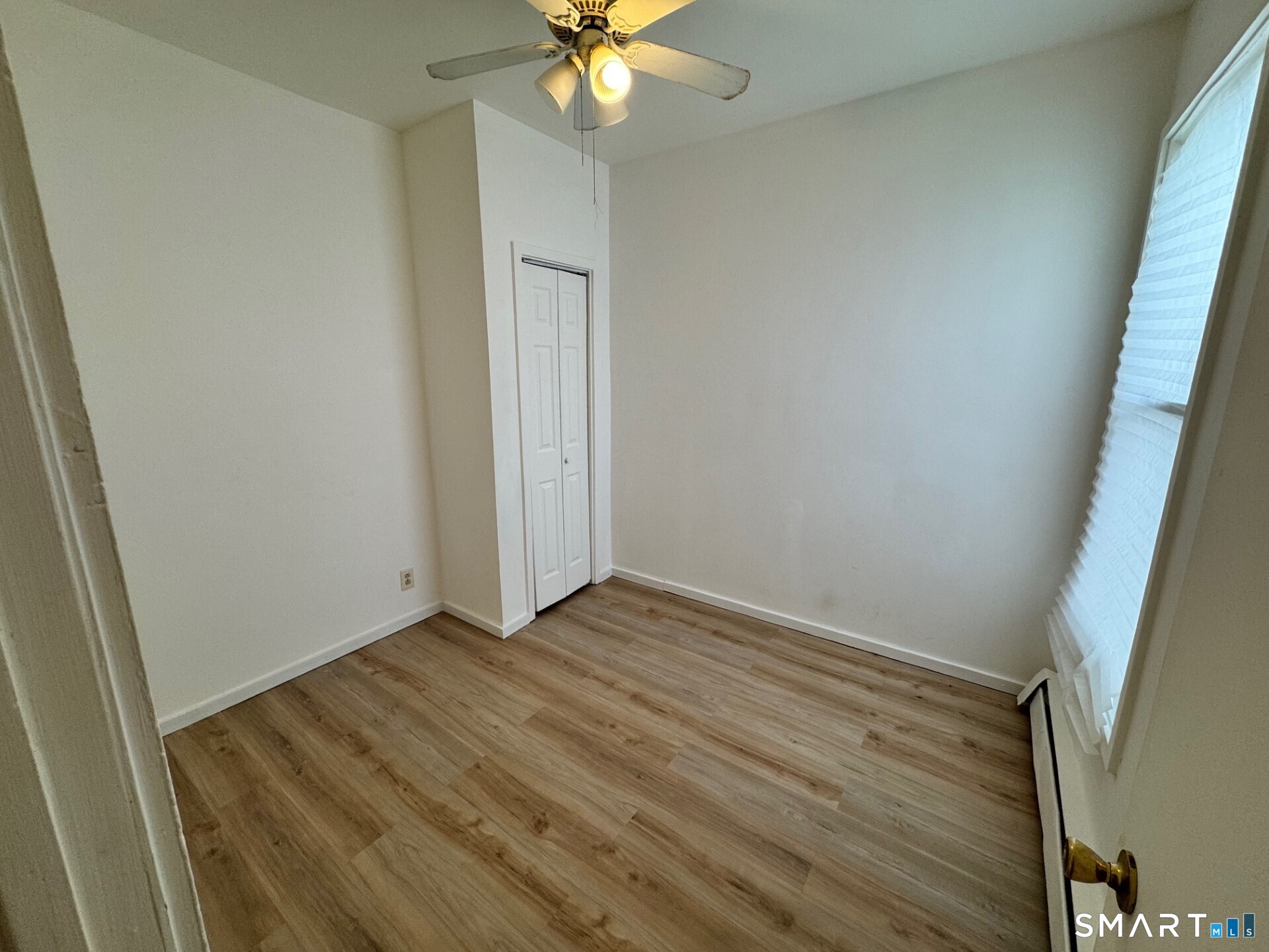 1 Seeley Street, Unit 2 Bridgeport, CT 06605 - Photo 5 of 8 an empty room with wooden floor and fan