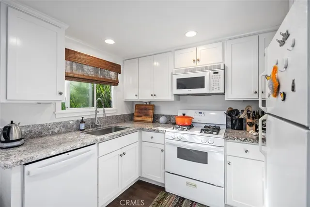 a kitchen with white cabinets and white appliances