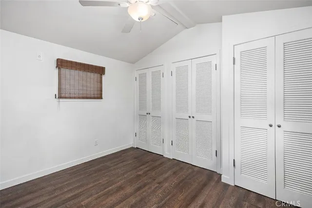 an empty room with wooden floor and ceiling fan