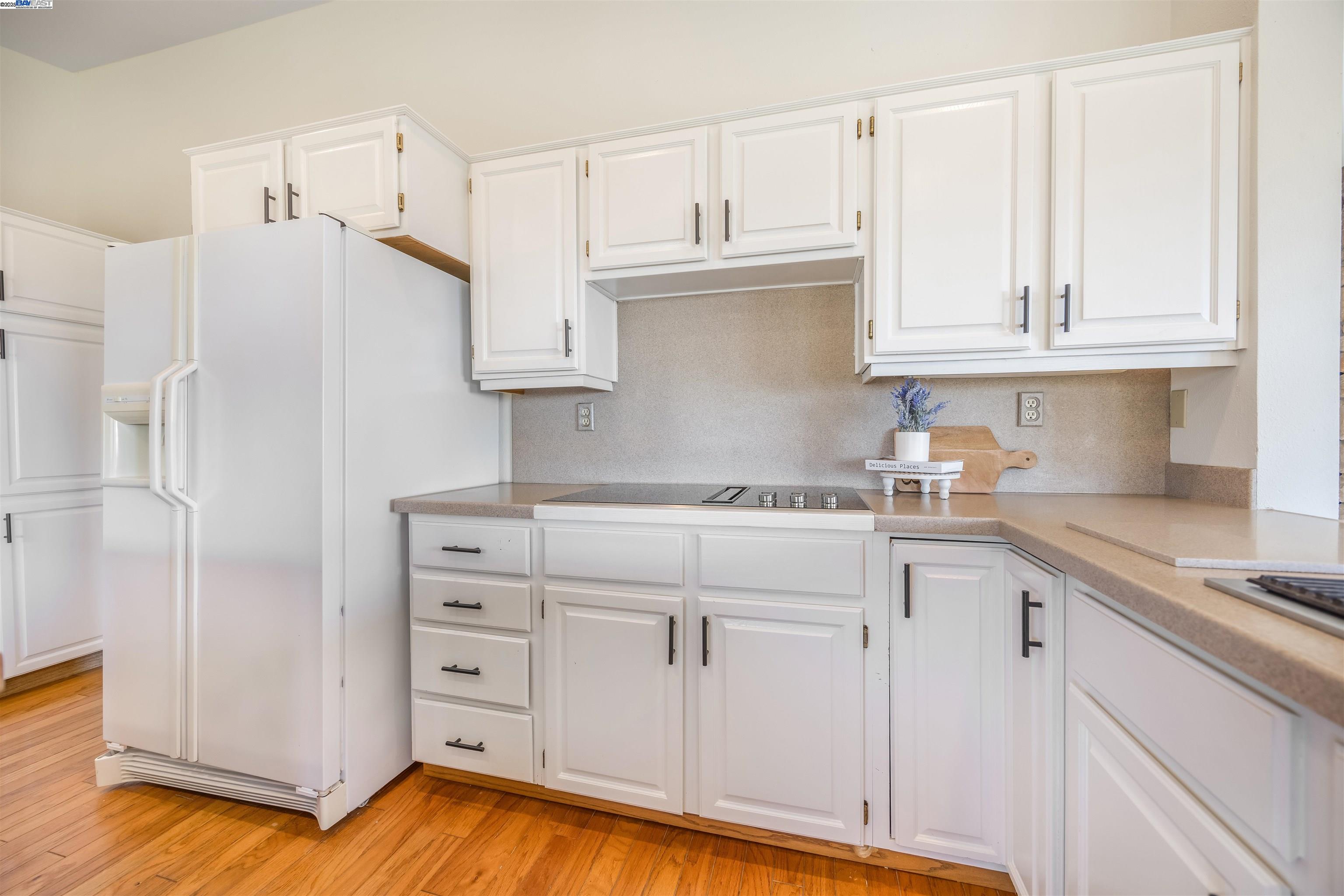 9050 Highland Road Livermore, CA 94551 - Photo 14 of 57 a kitchen with granite countertop white cabinets and refrigerator