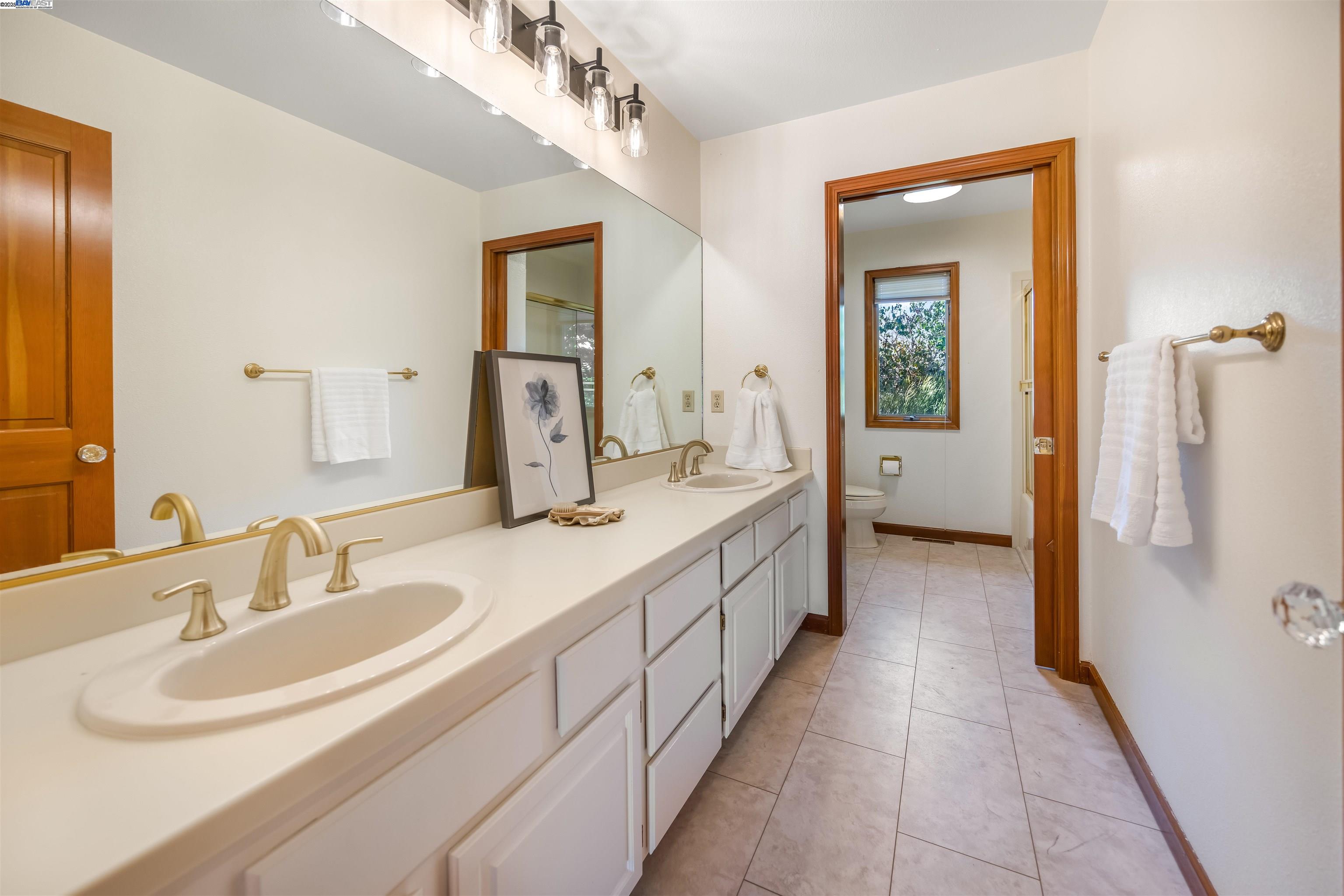 9050 Highland Road Livermore, CA 94551 - Photo 31 of 57 a bathroom with a double vanity sink and mirror