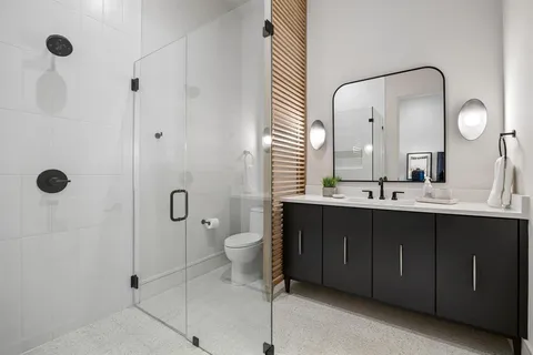 a bathroom with a double vanity sink mirror and toilet