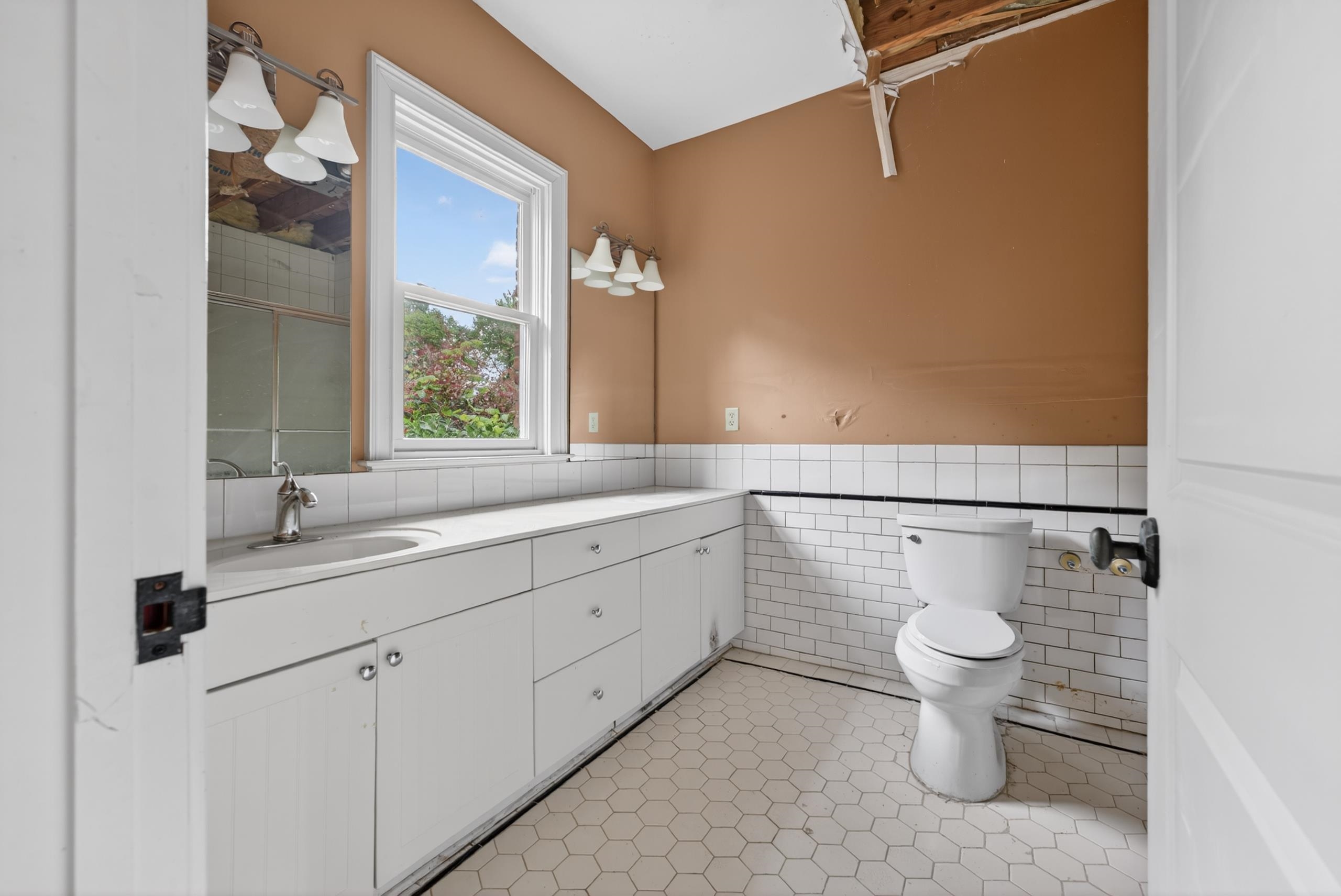 530 West Raines Road Memphis, TN 38109 - Photo 28 of 38 Bathroom featuring hexagon tile flooring, white subway tile wainscoting, and a window for natural light