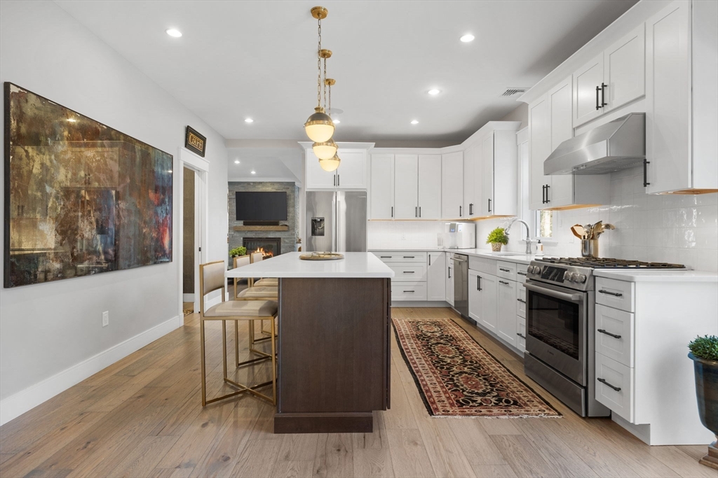 35 East Street Middleton, MA 01949 - Photo 11 of 42 a kitchen with stainless steel appliances kitchen island granite countertop a stove top oven a sink a counter space and cabinets