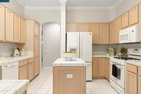 a spacious bedroom with a bed and a flat tv screen on a dresser