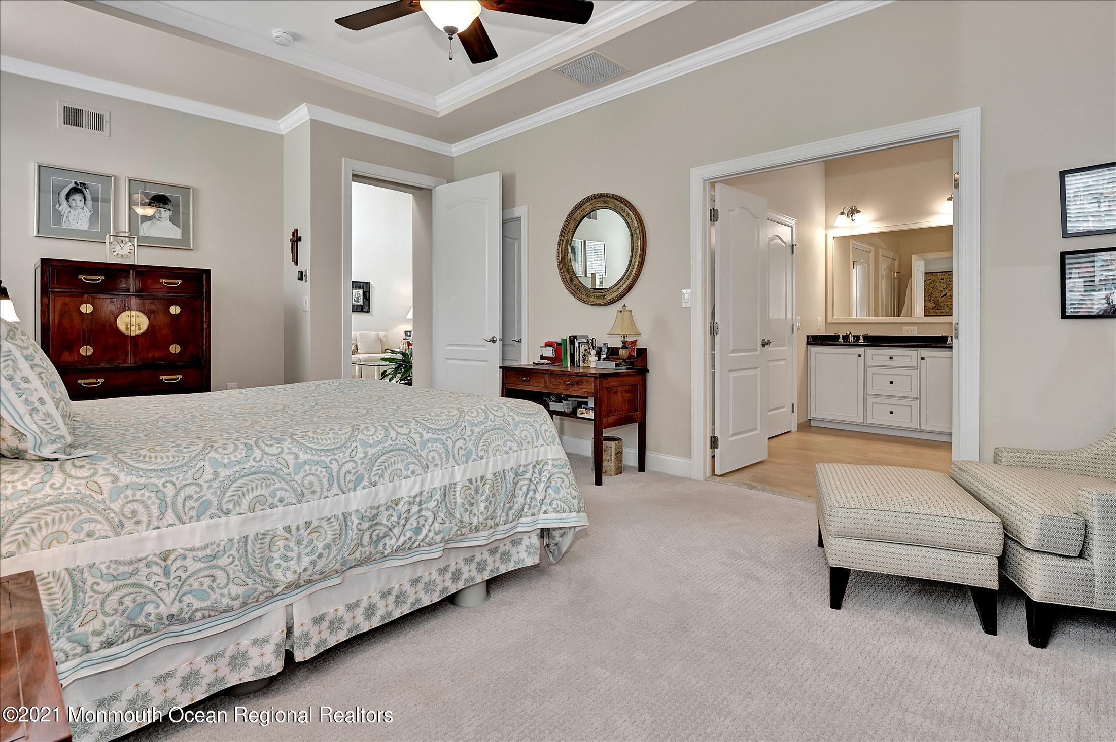 121 Sunset Drive Tinton Falls, NJ 07724 - Photo 16 of 40 a bedroom with a bed a mirror and a chandelier