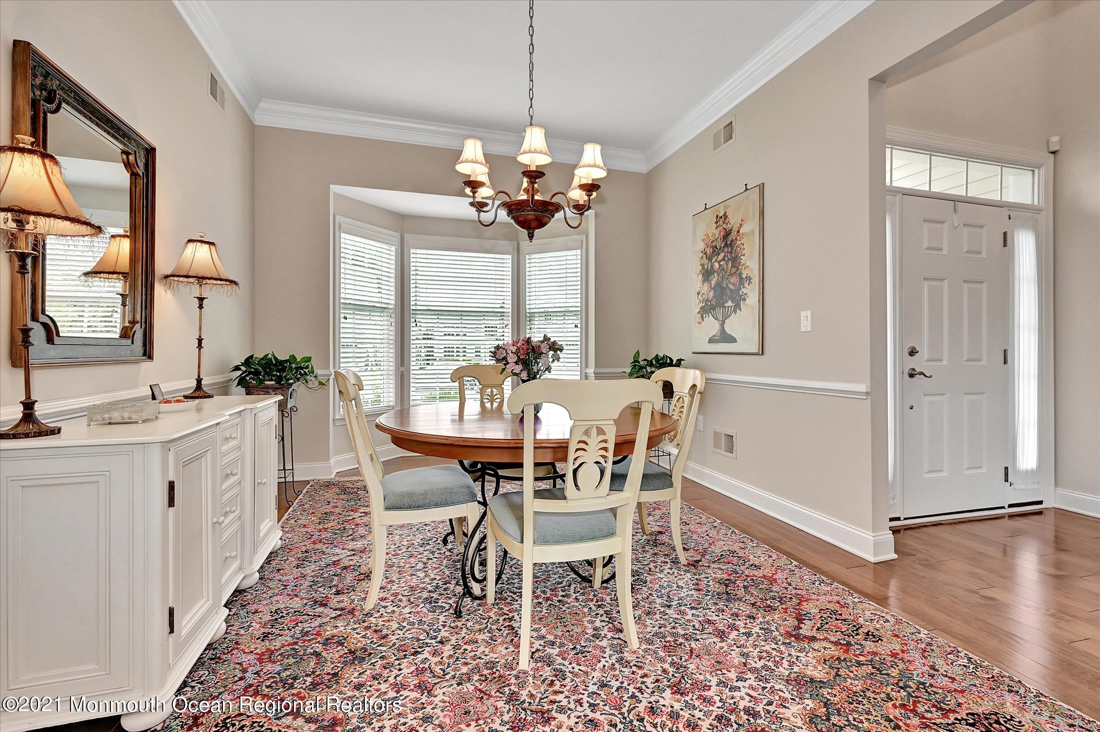 121 Sunset Drive Tinton Falls, NJ 07724 - Photo 4 of 40 a dining room with furniture a chandelier and wooden floor