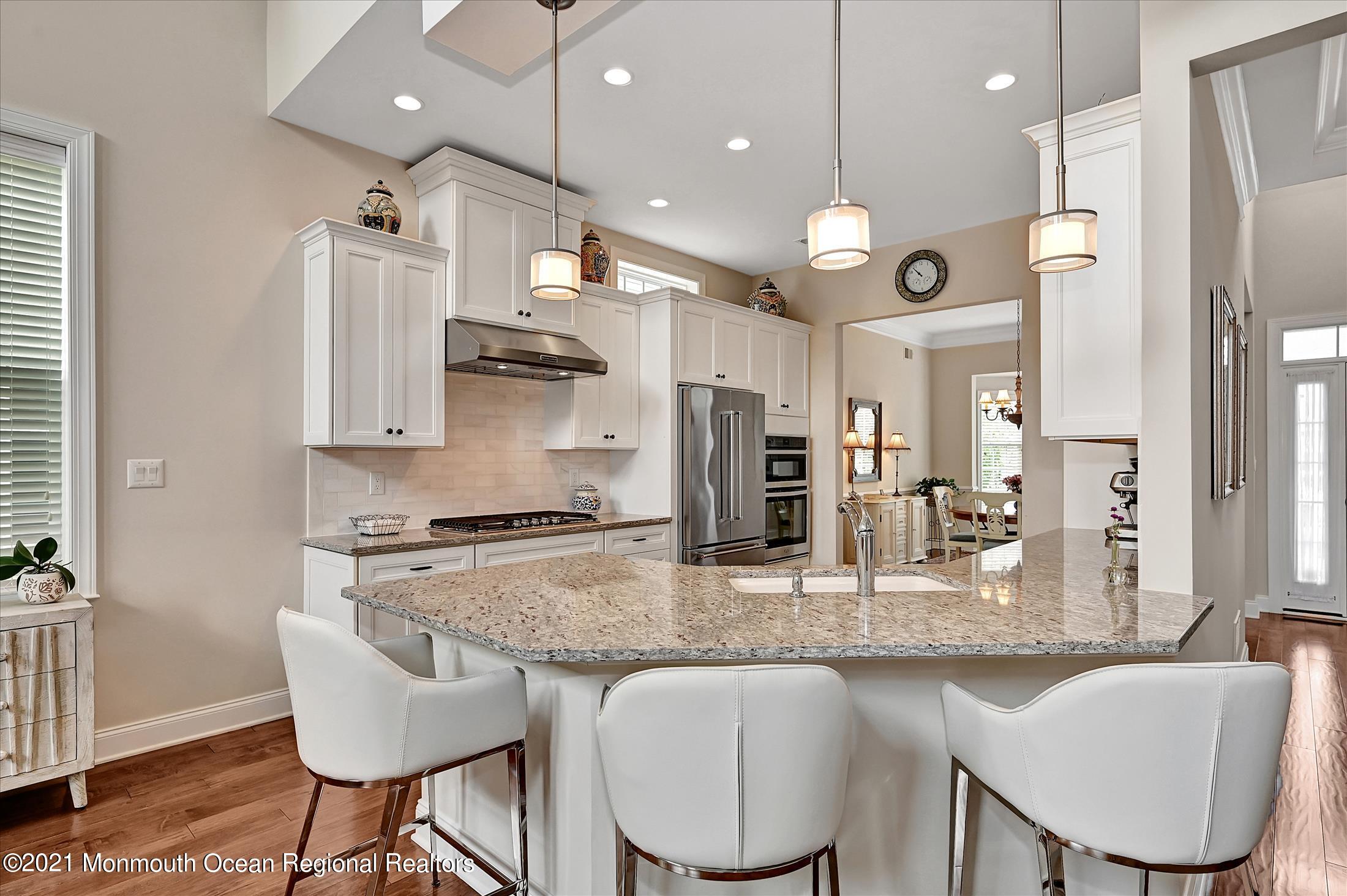 121 Sunset Drive Tinton Falls, NJ 07724 - Photo 7 of 40 a kitchen with granite countertop kitchen island stainless steel appliances a sink a stove a table and chairs