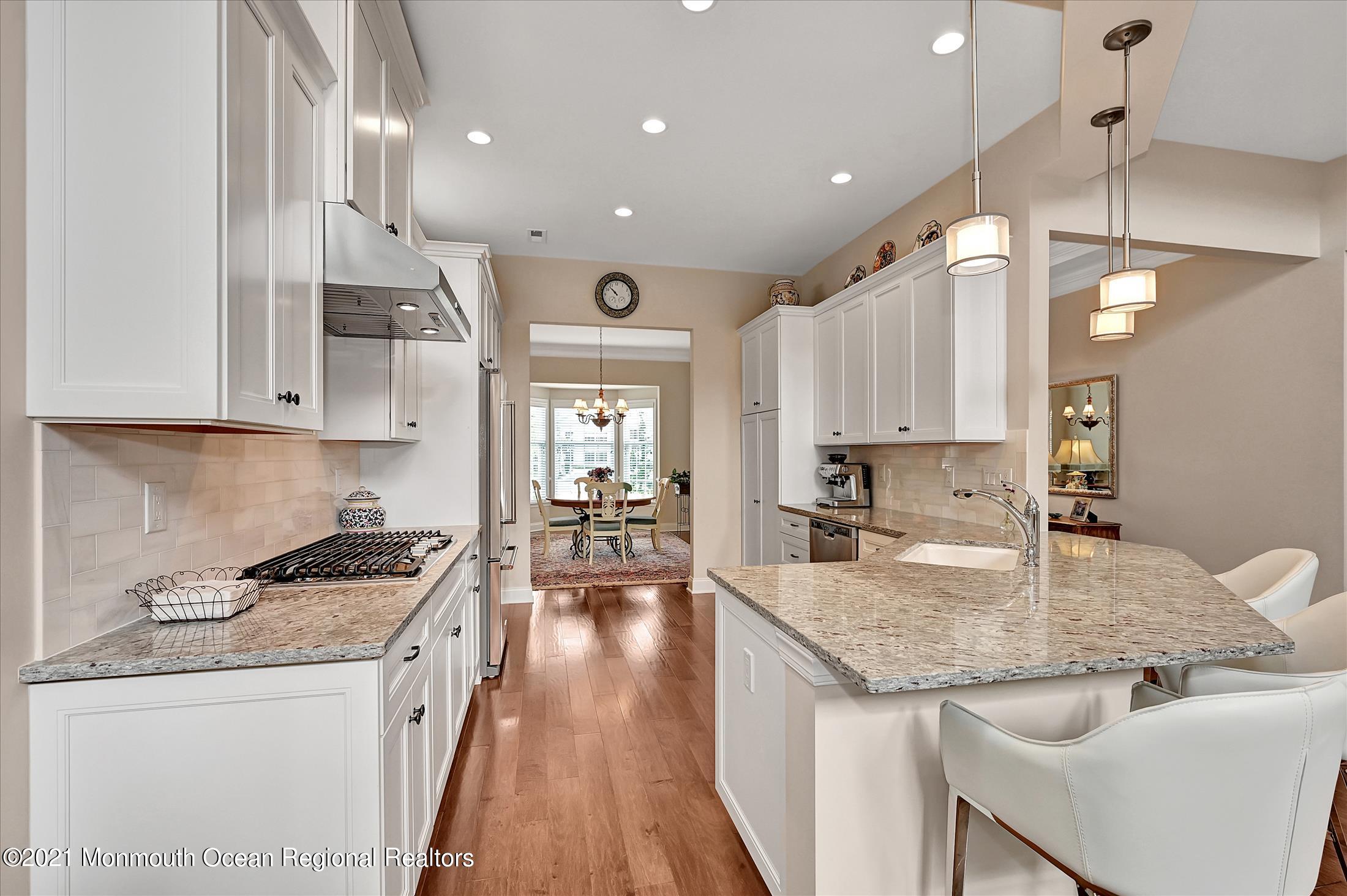 121 Sunset Drive Tinton Falls, NJ 07724 - Photo 8 of 40 a kitchen with granite countertop kitchen island stainless steel appliances a sink a stove a refrigerator and cabinets