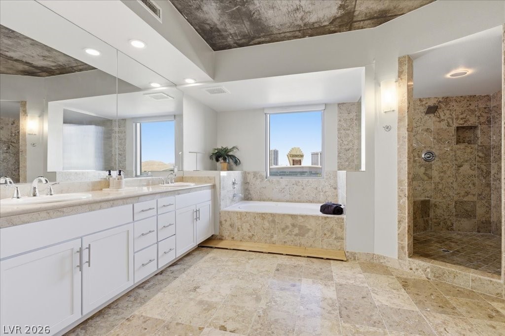 360 East Desert Inn Road, Unit 604 Las Vegas, NV 89109 - Photo 8 of 28 Marble finishes elevate this primary bath, complete with a dual vanity, soaking tub, and a separate shower.