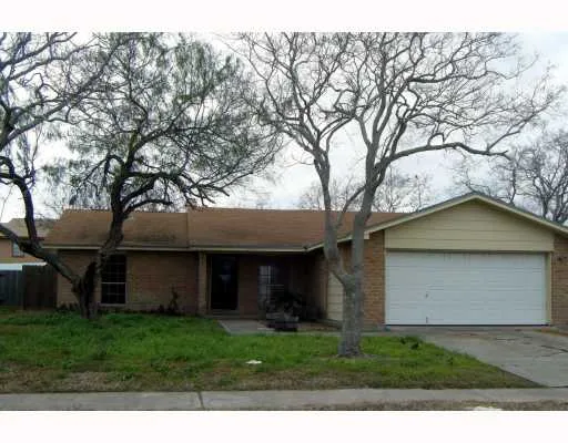 a view of a yard in front of a house with large tree