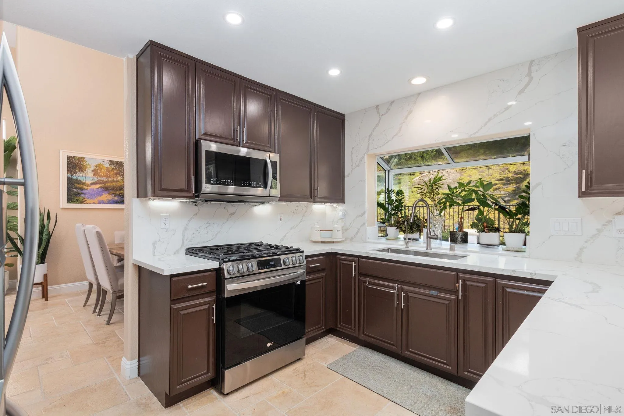 4532 Avenida Privado Oceanside, CA 92057 - Photo 13 of 40 a kitchen with stainless steel appliances a stove sink microwave and cabinets