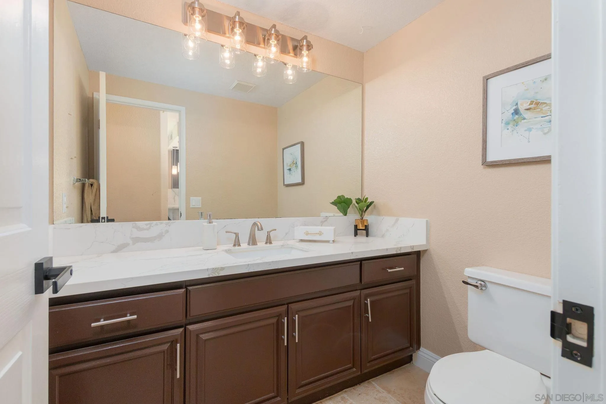 4532 Avenida Privado Oceanside, CA 92057 - Photo 15 of 40 a bathroom with a granite countertop toilet sink and mirror
