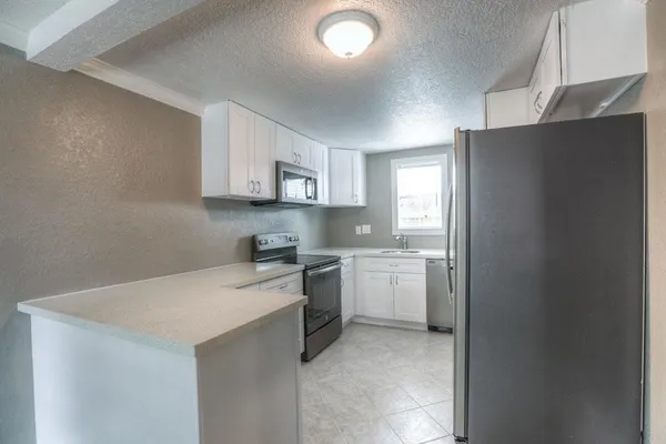 a kitchen with a refrigerator sink and cabinets