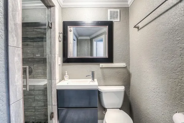 a bathroom with a toilet sink and mirror