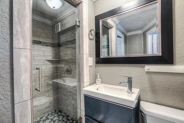 a bathroom with a sink a toilet and shower