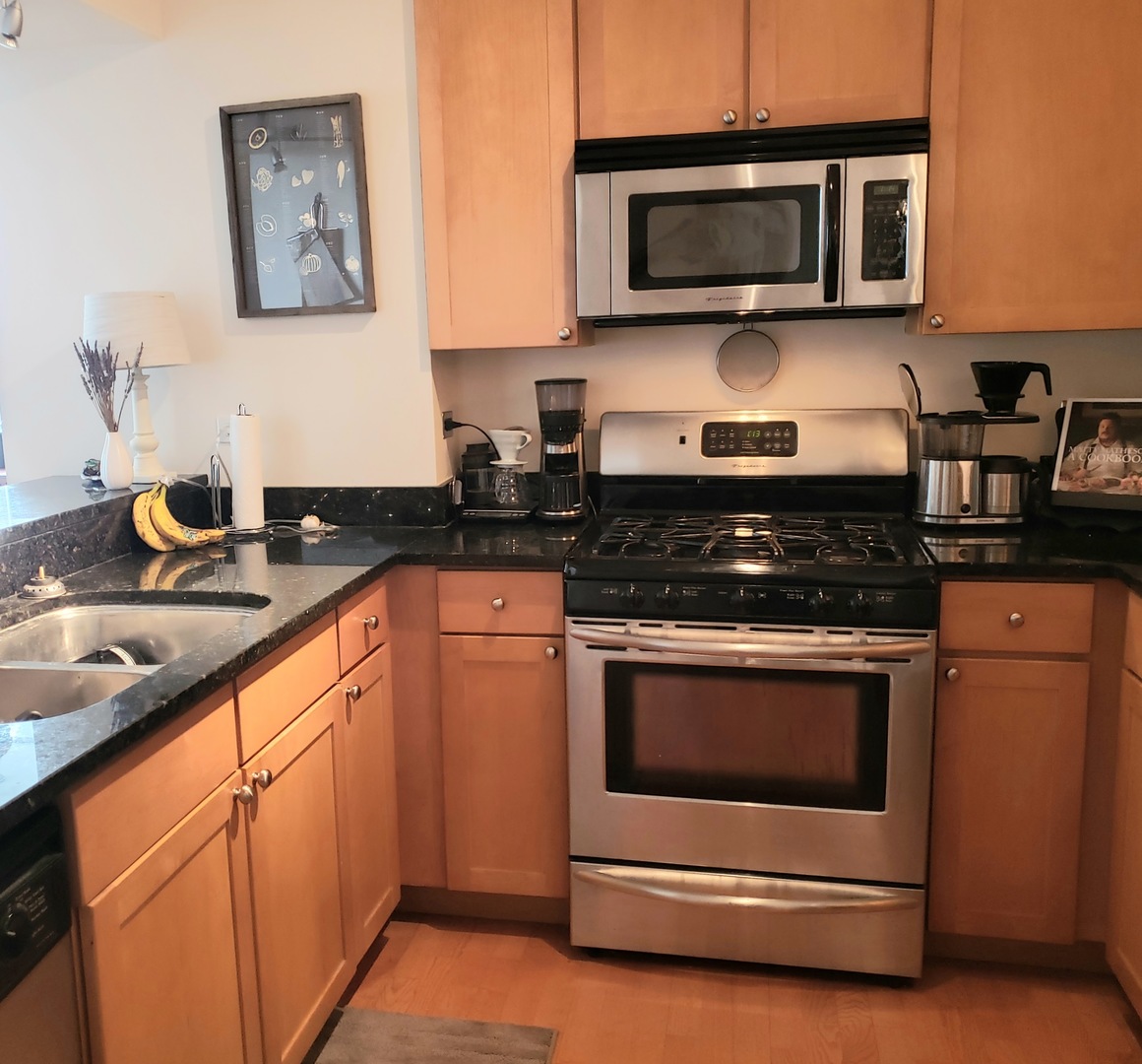 200 North Jefferson Street, Unit 601 Chicago, IL 60661 - Photo 7 of 27 a kitchen with stainless steel appliances granite countertop a stove and a microwave