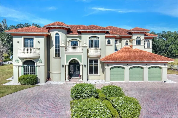 a front view of a house with yard and parking