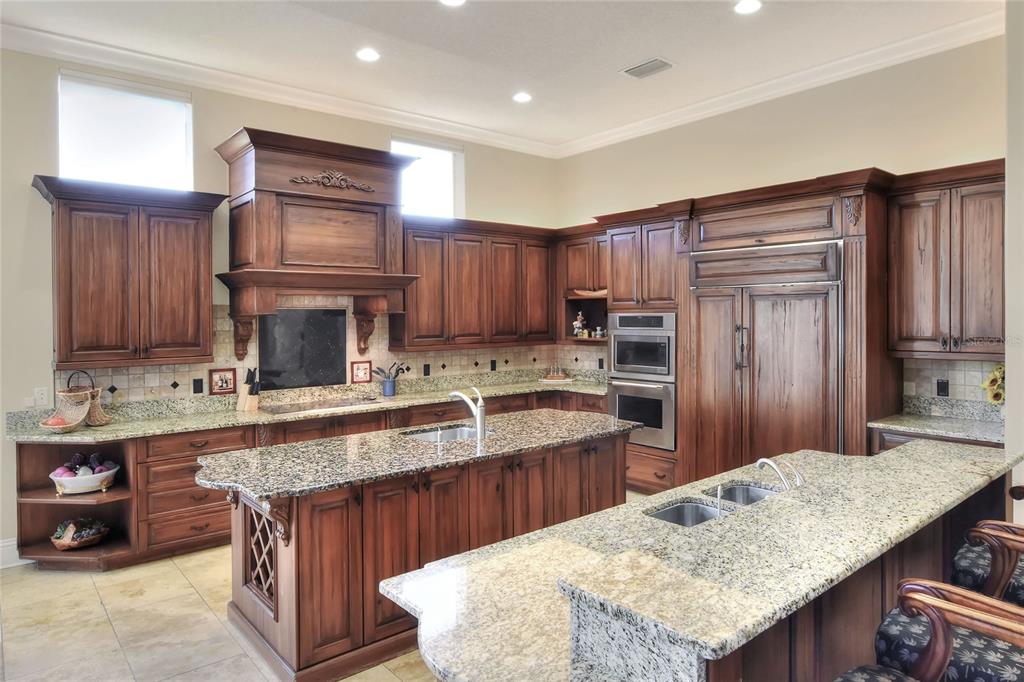 4215 Sb Merrion Road Lakeland, FL 33810 - Photo 18 of 95 a kitchen with kitchen island granite countertop wooden cabinets a sink dishwasher stove and refrigerator with wooden floor