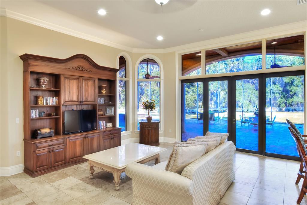 4215 Sb Merrion Road Lakeland, FL 33810 - Photo 20 of 95 a living room with furniture a flat screen tv and a floor to ceiling window