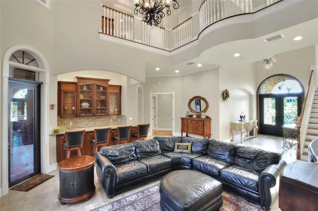 a living room with furniture a flat screen tv and a floor to ceiling window