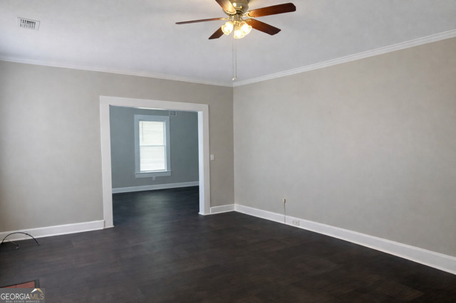 405 South Leroy Street Metter, GA 30439 - Photo 3 of 25 an empty room with wooden floor fan and windows