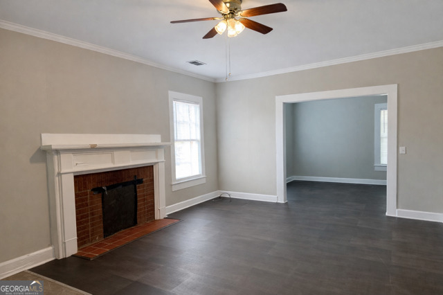 405 South Leroy Street Metter, GA 30439 - Photo 4 of 25 a view of an empty room with chandelier fan and fire place