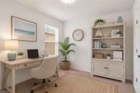 a view of a workspace with furniture and a window