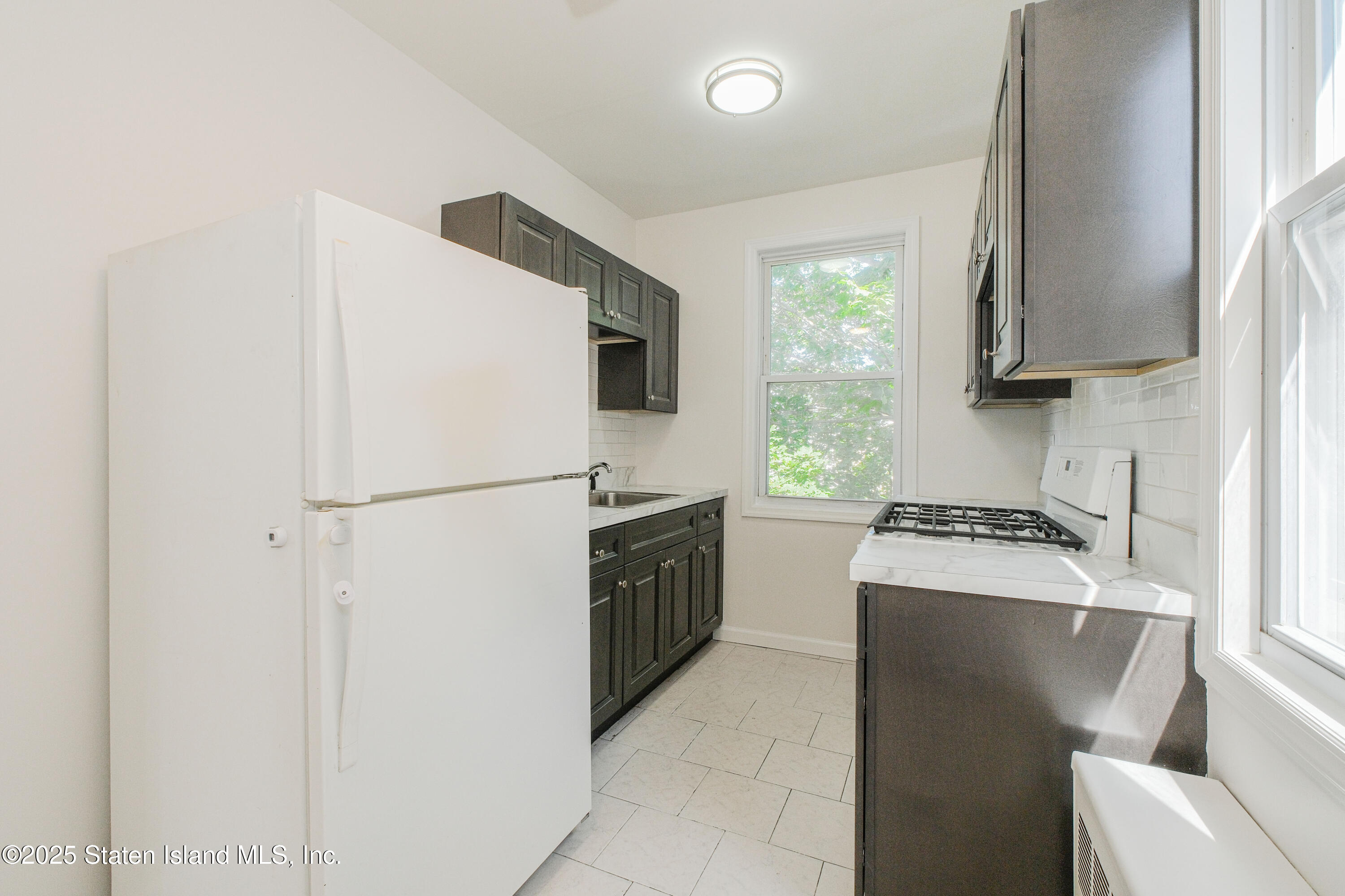 435 Castleton Avenue Staten Island, NY 10301 - Photo 21 of 47 a kitchen with a refrigerator sink stove and microwave