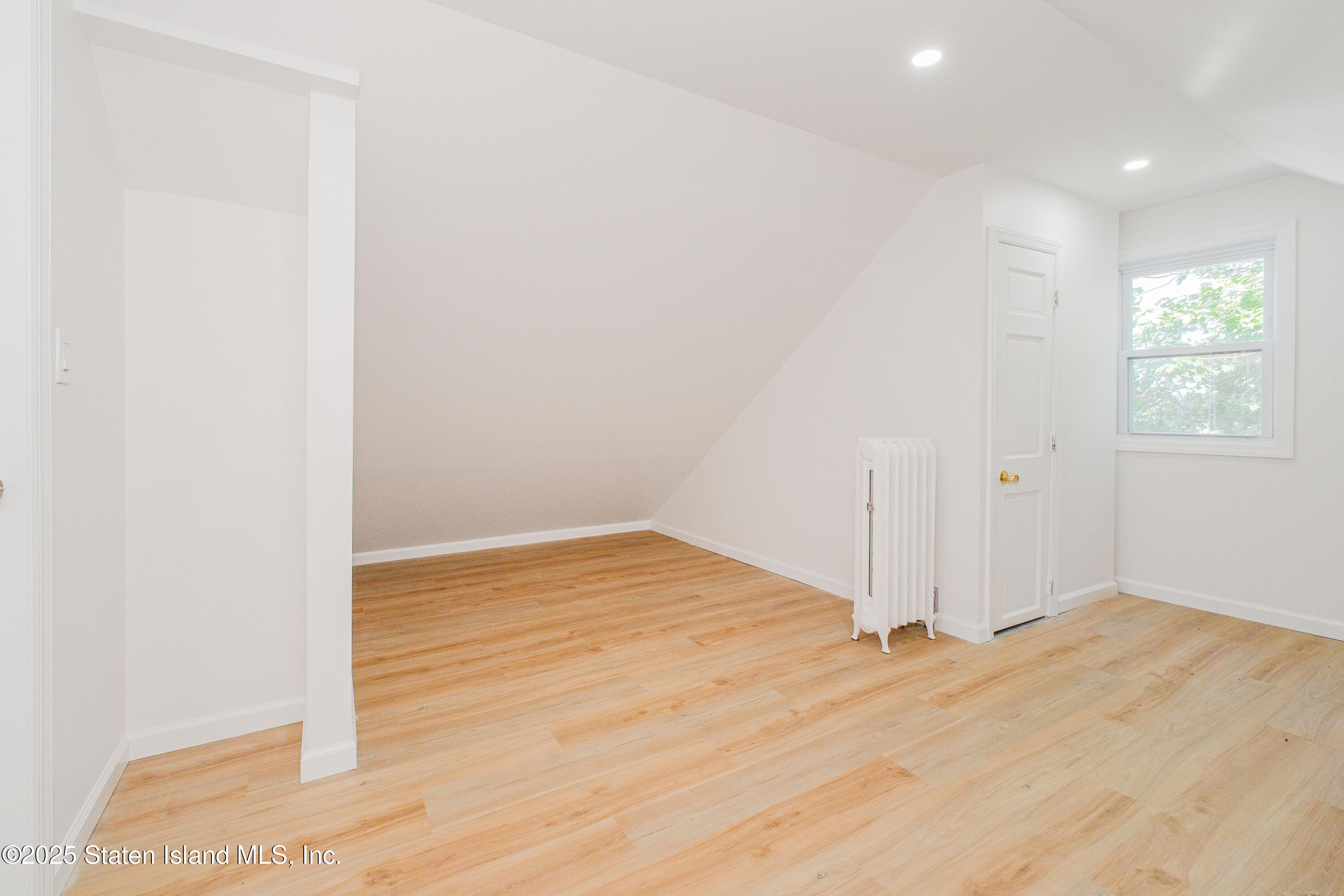 435 Castleton Avenue Staten Island, NY 10301 - Photo 26 of 47 a view of empty room with wooden floor and fan