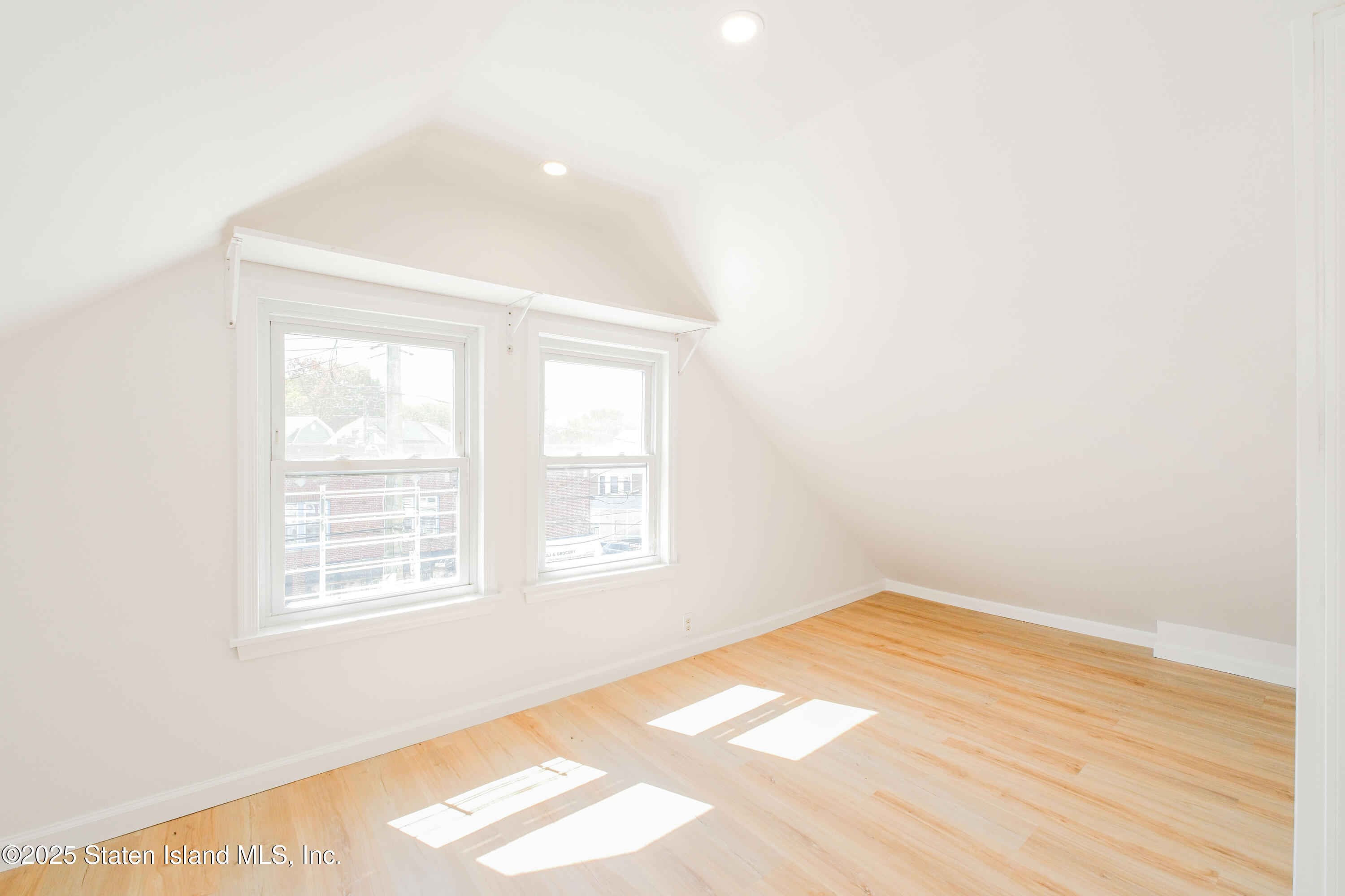 435 Castleton Avenue Staten Island, NY 10301 - Photo 27 of 47 an empty room with wooden floor and windows