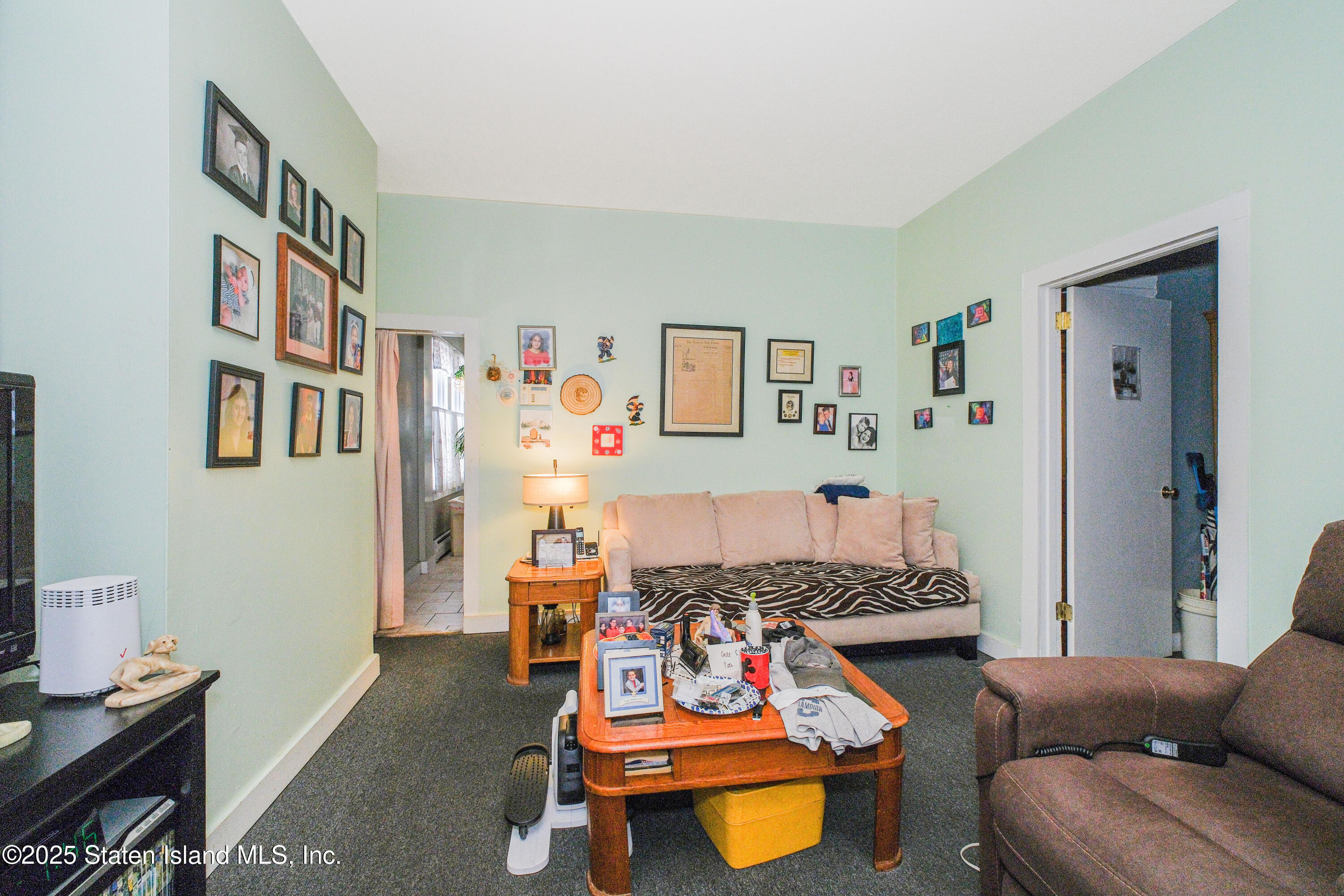 435 Castleton Avenue Staten Island, NY 10301 - Photo 31 of 47 a living room with furniture and a baby crib with wooden floor