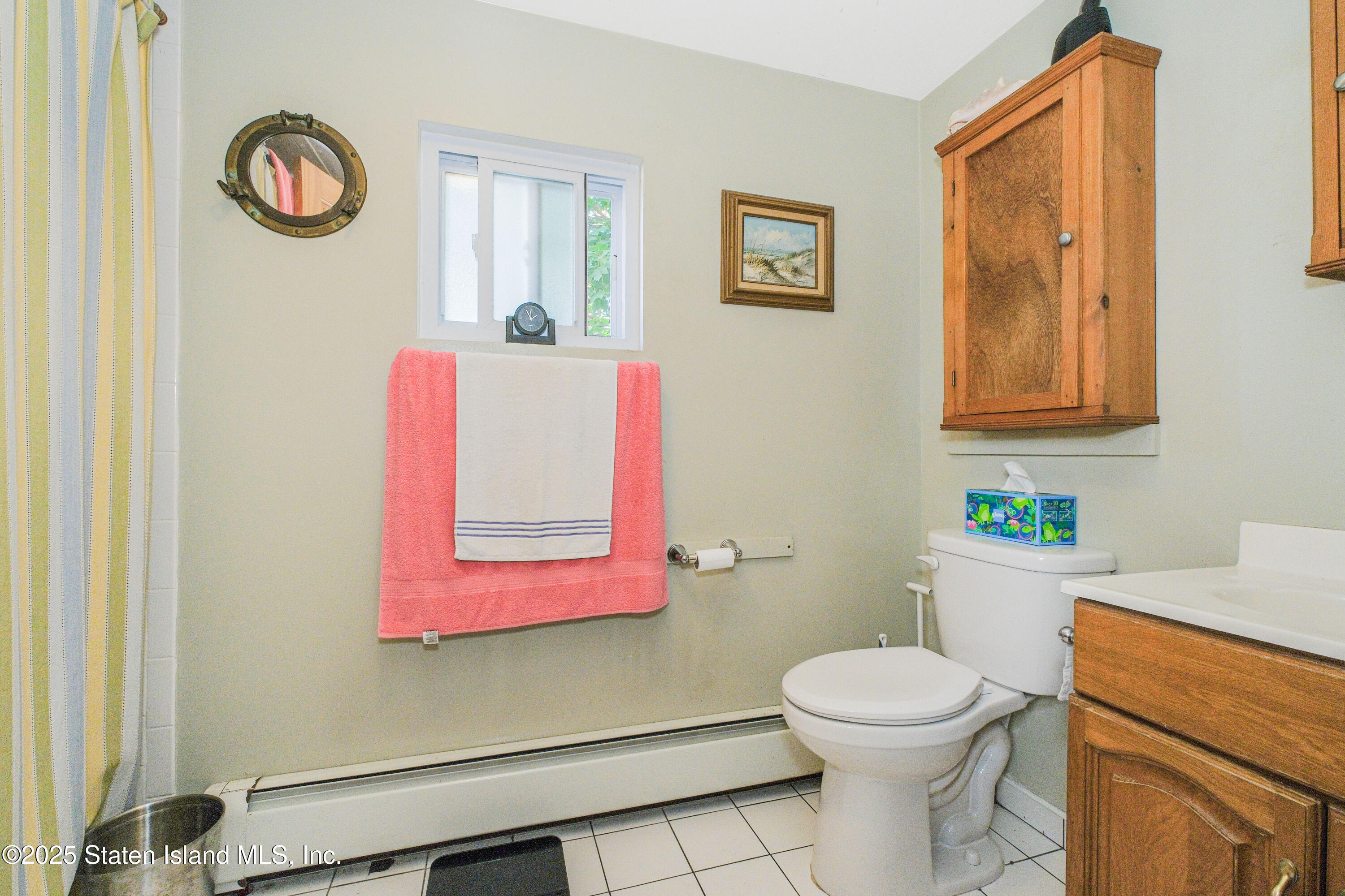 435 Castleton Avenue Staten Island, NY 10301 - Photo 42 of 47 a bathroom with a toilet a sink and a mirror