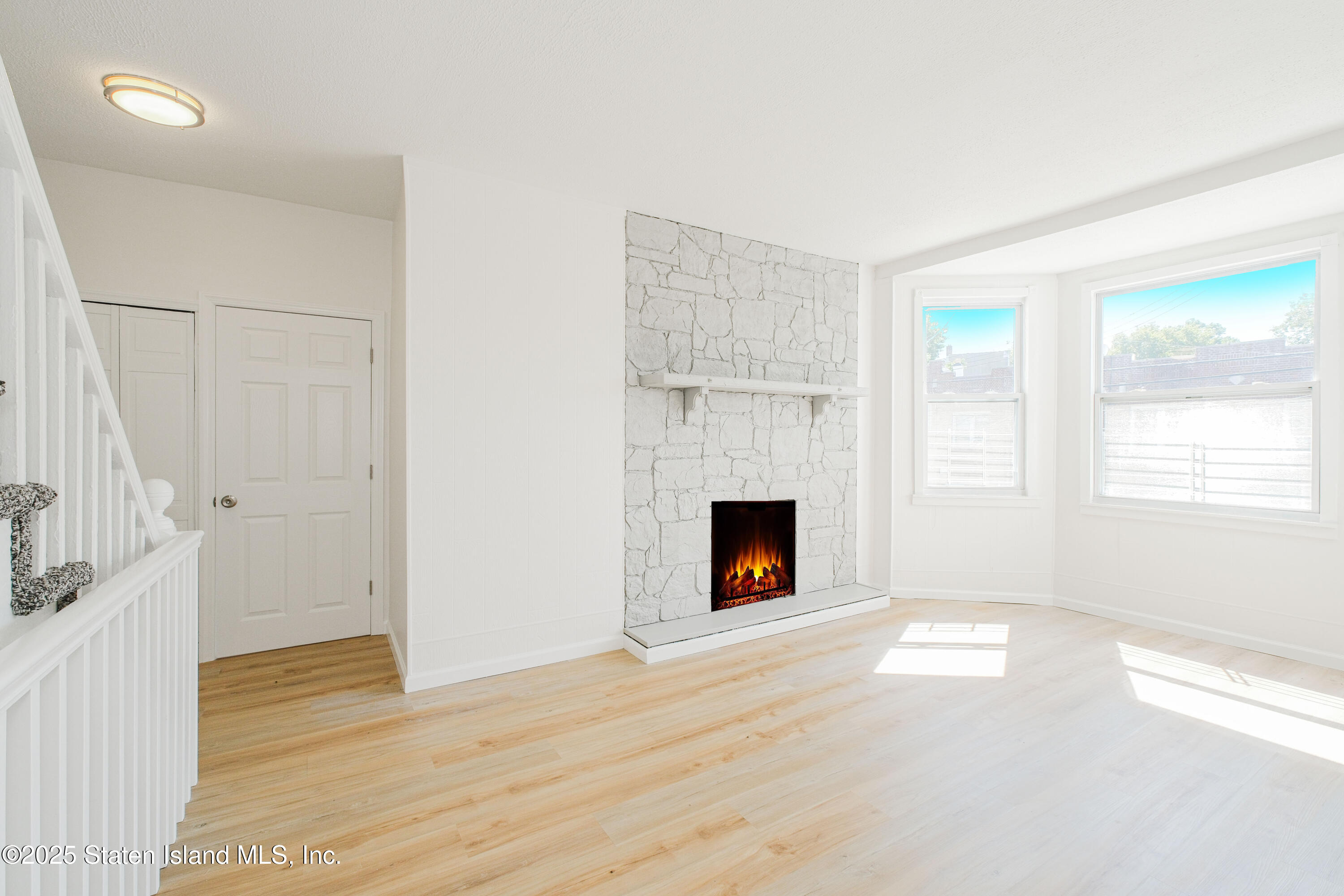 435 Castleton Avenue Staten Island, NY 10301 - Photo 5 of 47 a view of an empty room with wooden floor fireplace and a window