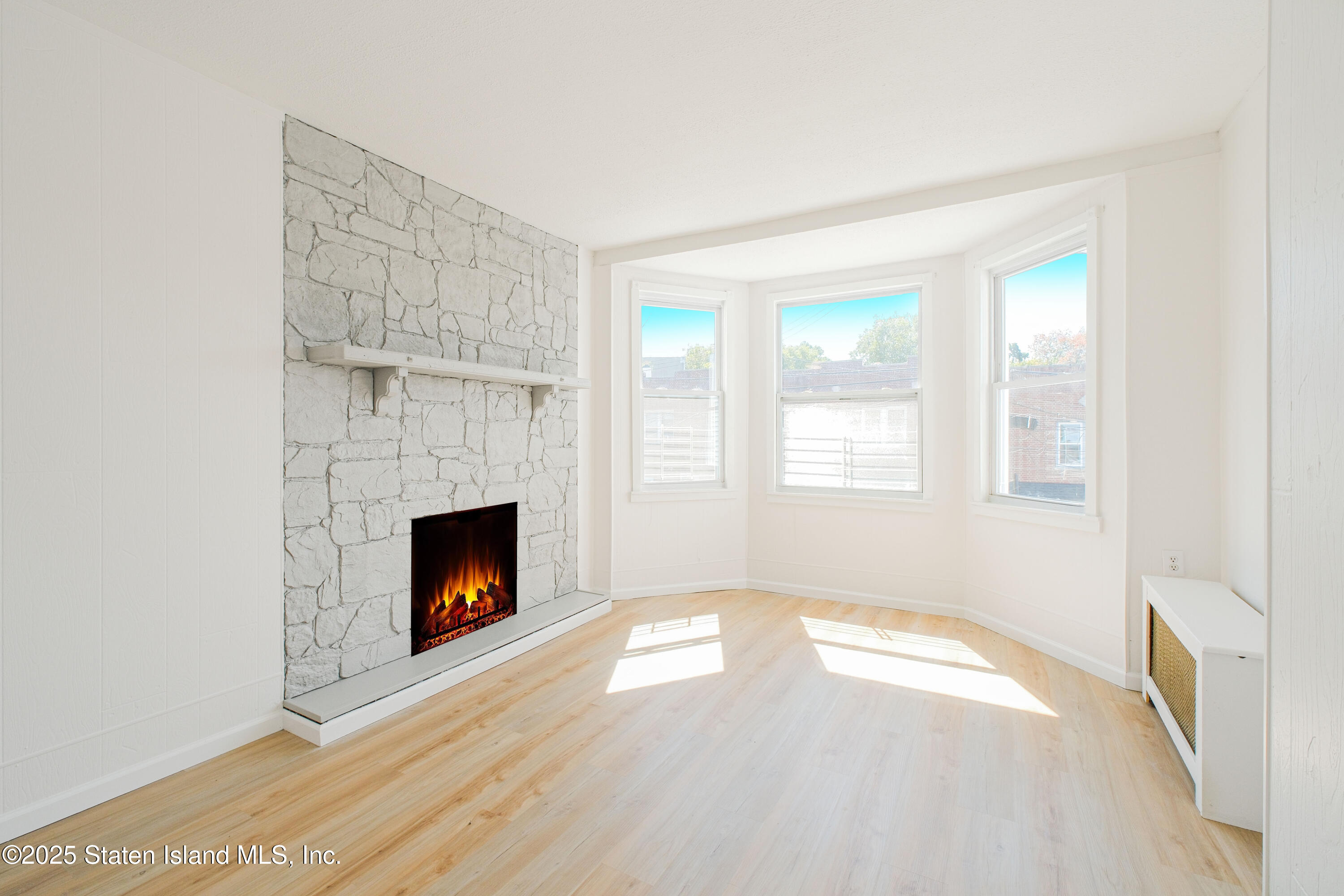 435 Castleton Avenue Staten Island, NY 10301 - Photo 7 of 47 a view of an empty room with a fireplace and a window