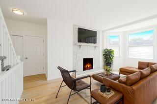 435 Castleton Avenue Staten Island, NY 10301 - Photo 9 of 47 a living room with furniture a flat screen tv and a fireplace