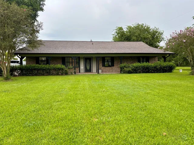 a front view of a house with yard and green space