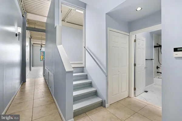 a view of a hallway with a door and stairs