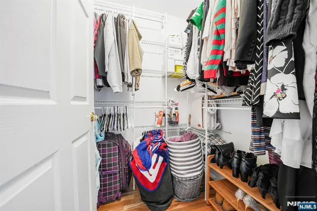a view of walk in closet with clothes and shoes