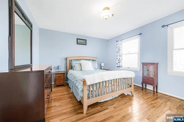 a bedroom with a bed and a window with wooden floor