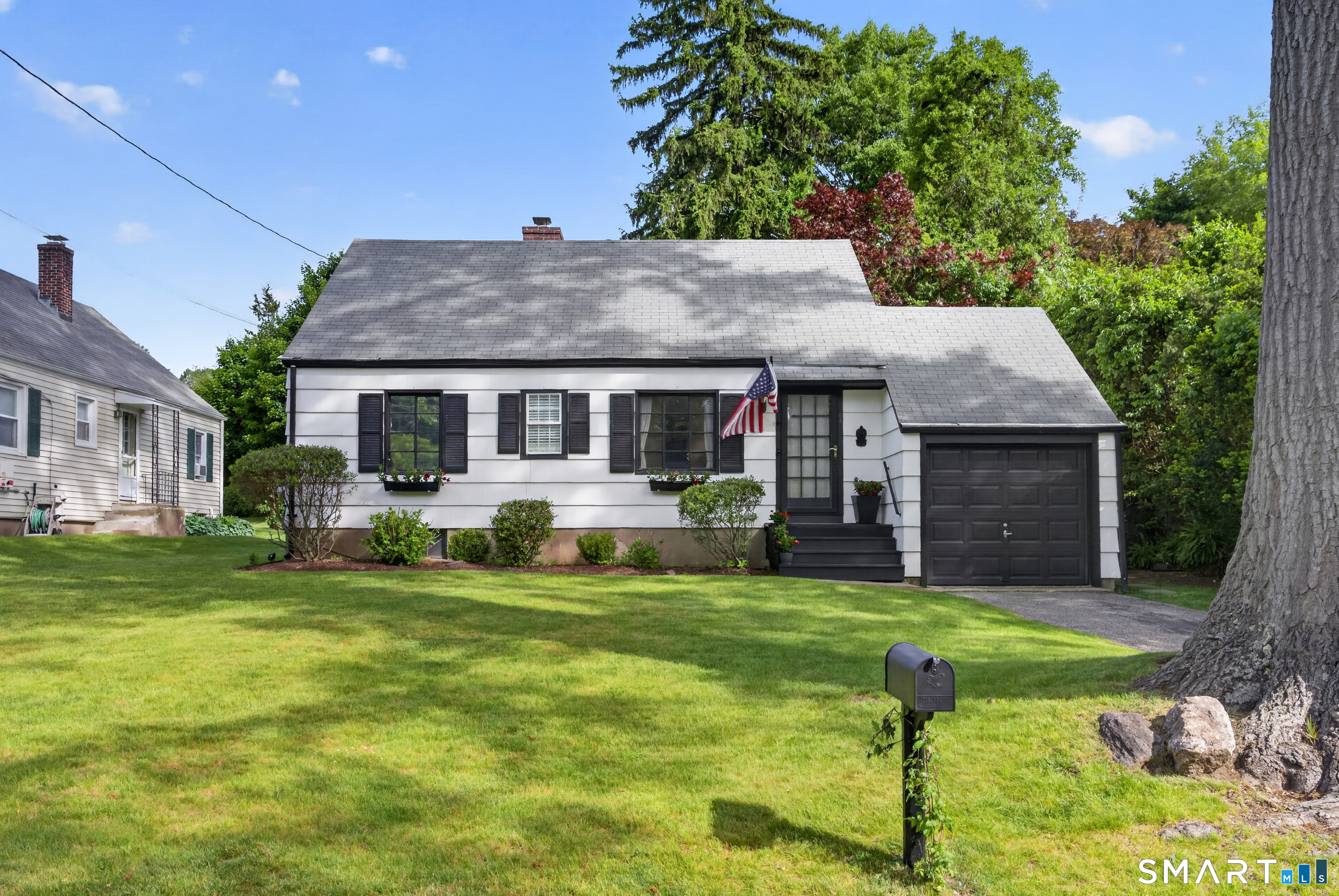 68 Old Elm Road Fairfield, CT 06825 - Photo 1 of 40 a front view of a house with a yard table and chairs