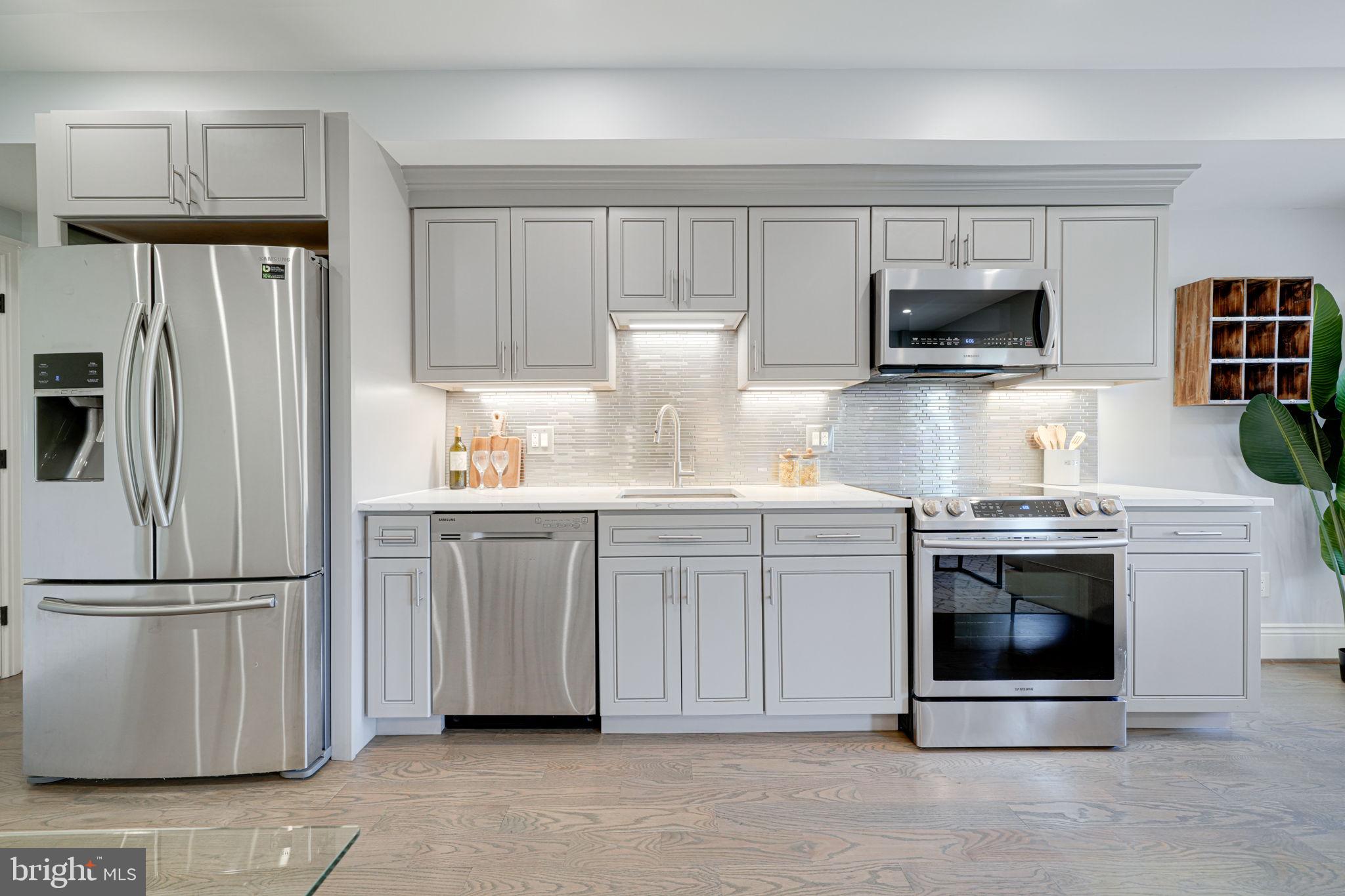 1728 D Street Southeast, Unit 2 Washington, DC 20003 - Photo 10 of 54 a kitchen with white cabinets and stainless steel appliances