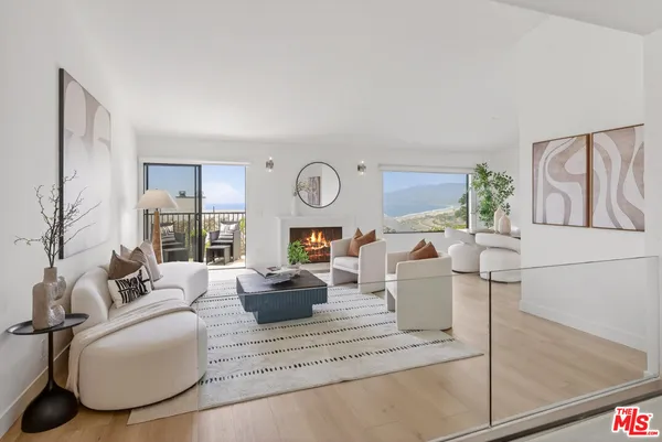 a living room with furniture a fireplace and a potted plant