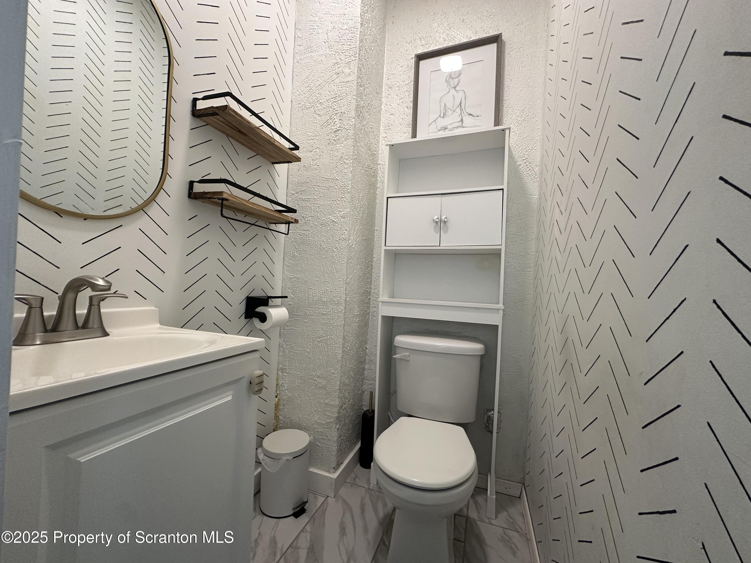821 Maple Street Scranton, PA 18505 - Photo 10 of 21 a bathroom with a toilet sink and mirror