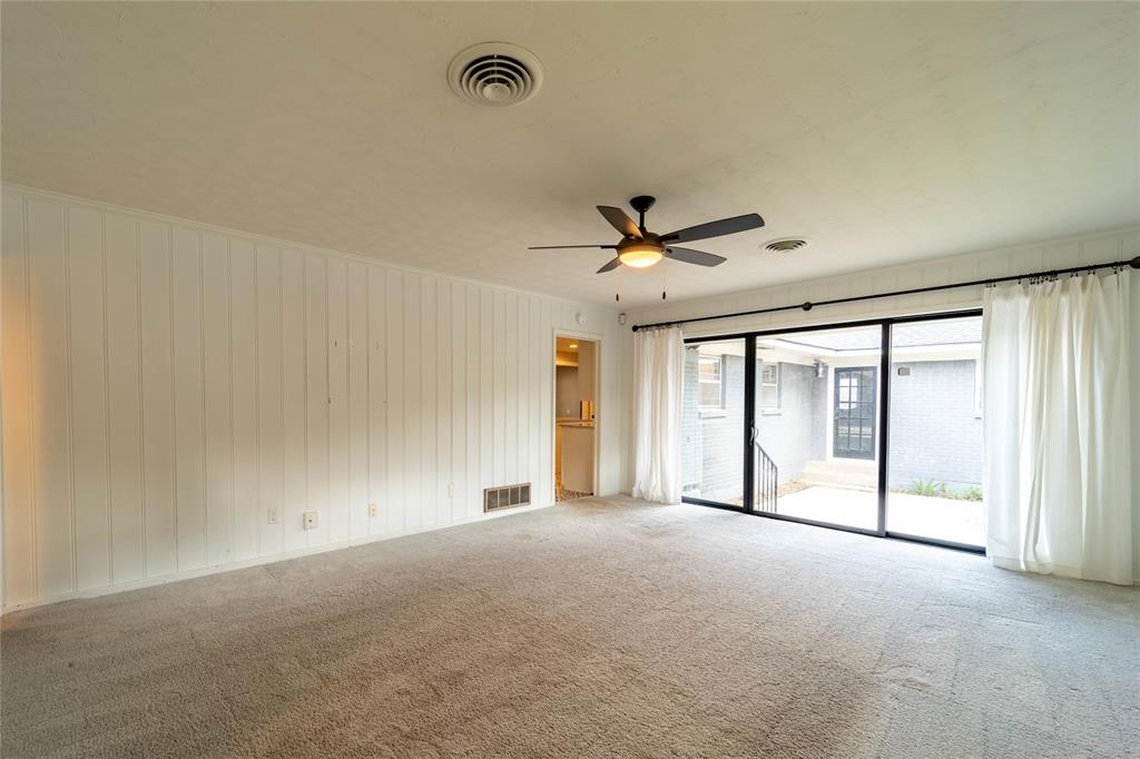 9823 Mercer Drive Dallas, TX 75228 - Photo 13 of 40 Large game room has half bath and doors to patio - let the light pour in. Carpet has been updated (January 2026)