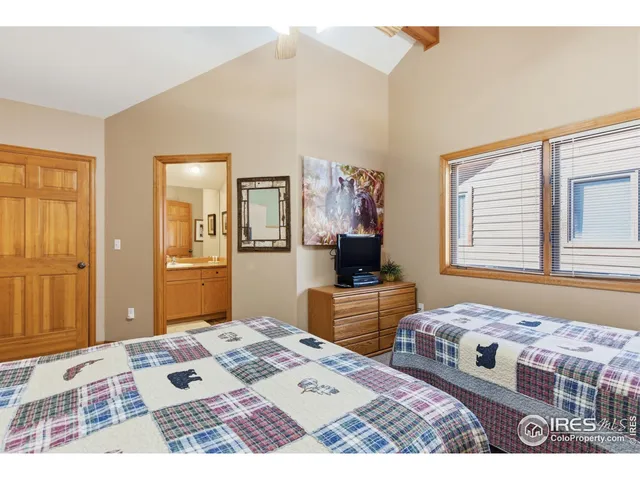 a bedroom with a bed dresser and a flat screen tv