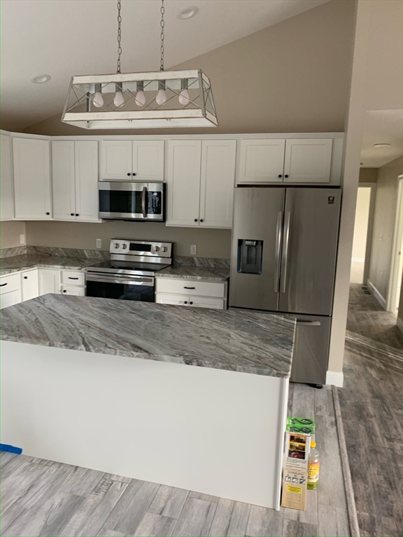 86 Beaumont Avenue Chicopee, MA 01013 - Photo 2 of 8 a kitchen with stainless steel appliances granite countertop a sink a stove a microwave a refrigerator a counter top and cabinets
