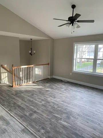 a view of an empty room with a window and a ceiling fan