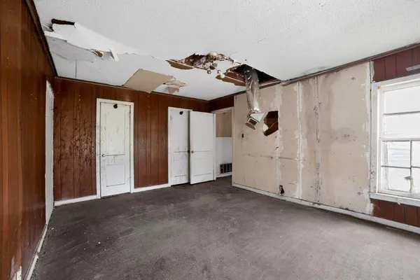 a view of an empty room with a fireplace and a window
